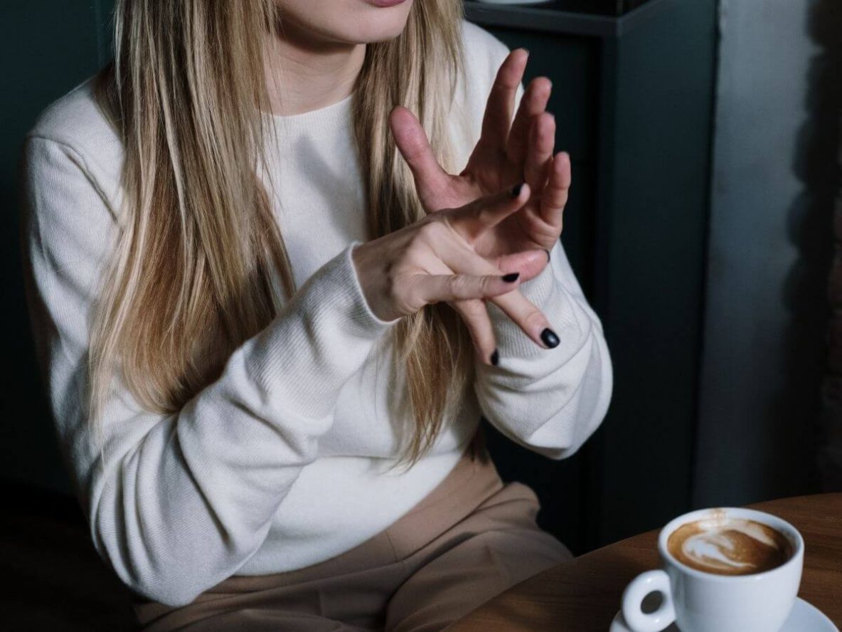 woman in coffee shop using sign language