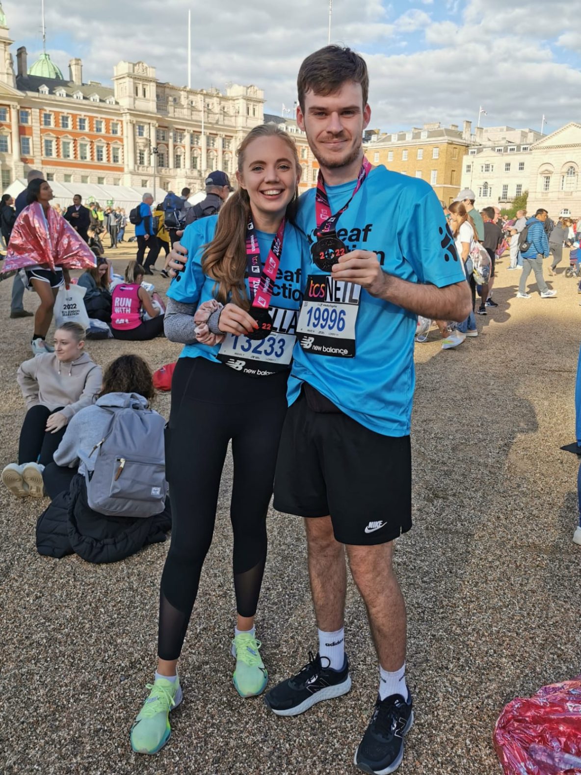 two people showing their London Marathon finisher medals