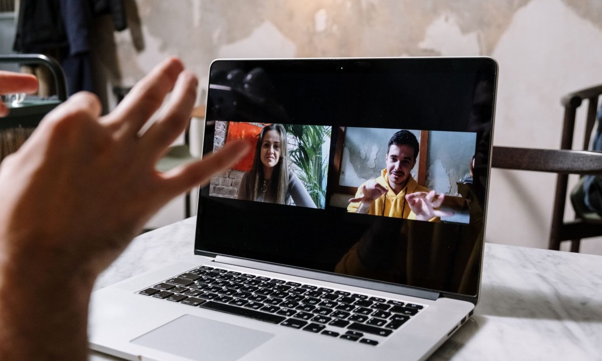 A laptop screen with two people on a Zoom video call