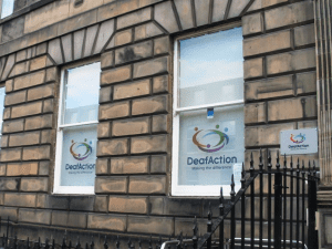 Front of Deaf Action's buidling with old branding on windows